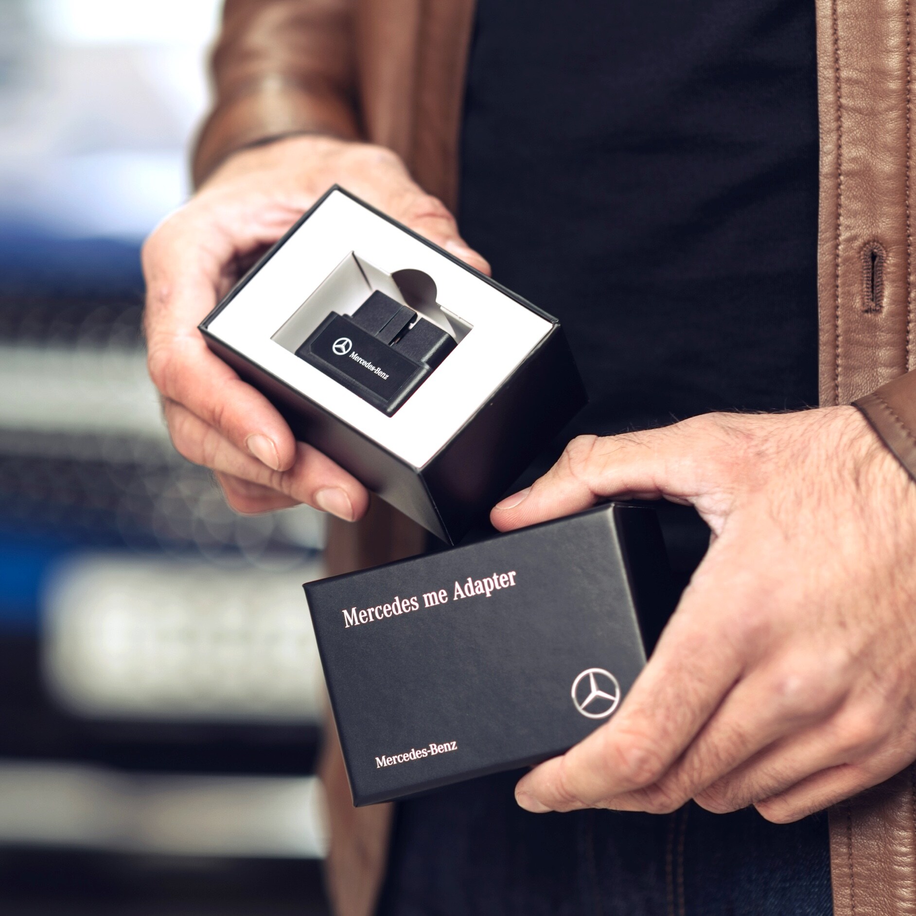 A man unpacks the Mercedes-Benz Adapter for his Mercedes-Benz to be able to use Digital Extras in his vehicle. A man unpacks the Mercedes-Benz Adapter for his Mercedes-Benz to be able to use Digital Extras in his vehicle.